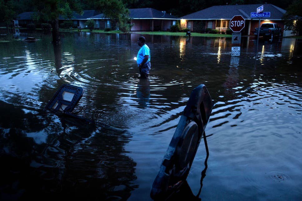 Tracy Thornton walks to his house through a flooded neighborhood August 15, 2016 in Baton Rouge, Louisiana