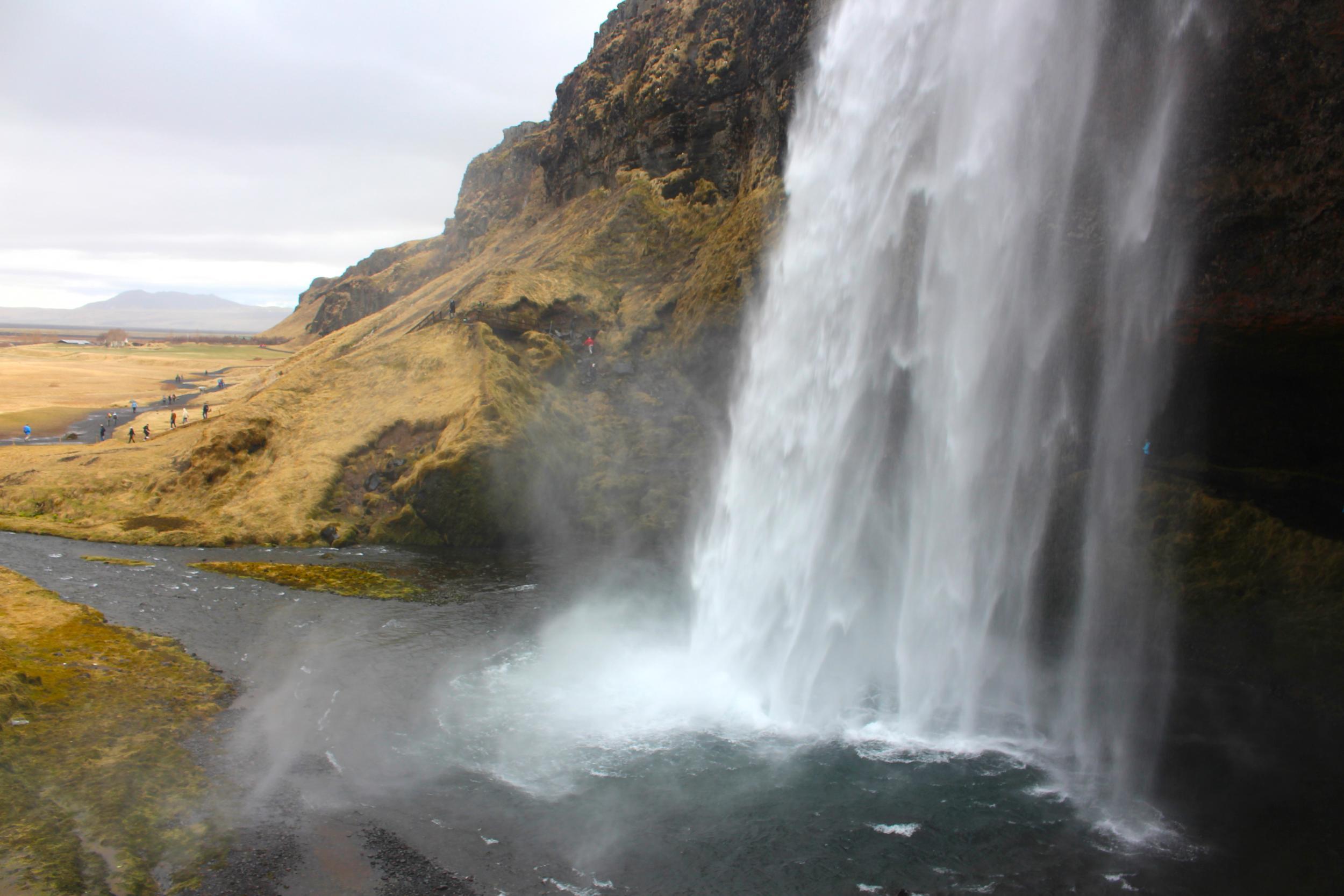 Tourists can stand behind the Seljalandsfoss waterfall to get the perfect shot