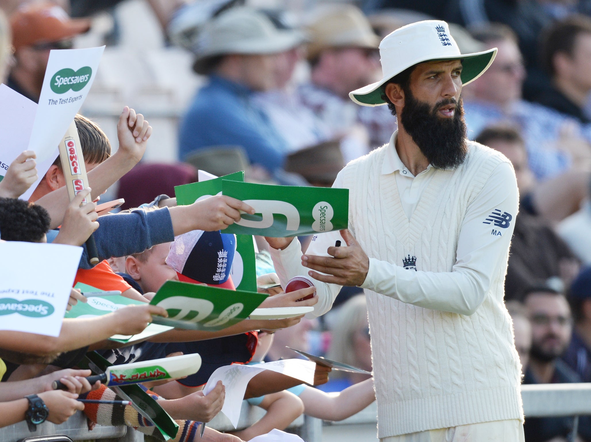 Moeen Ali of England signs autographs during the second day