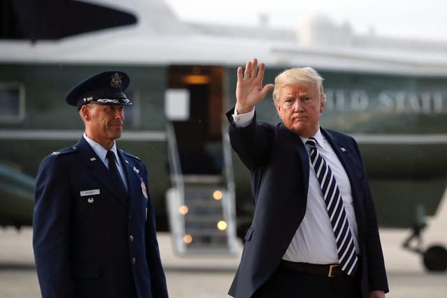 President Donald Trump waves to members of the media after arriving on Air Force One, Friday, Aug. 31, 2018
