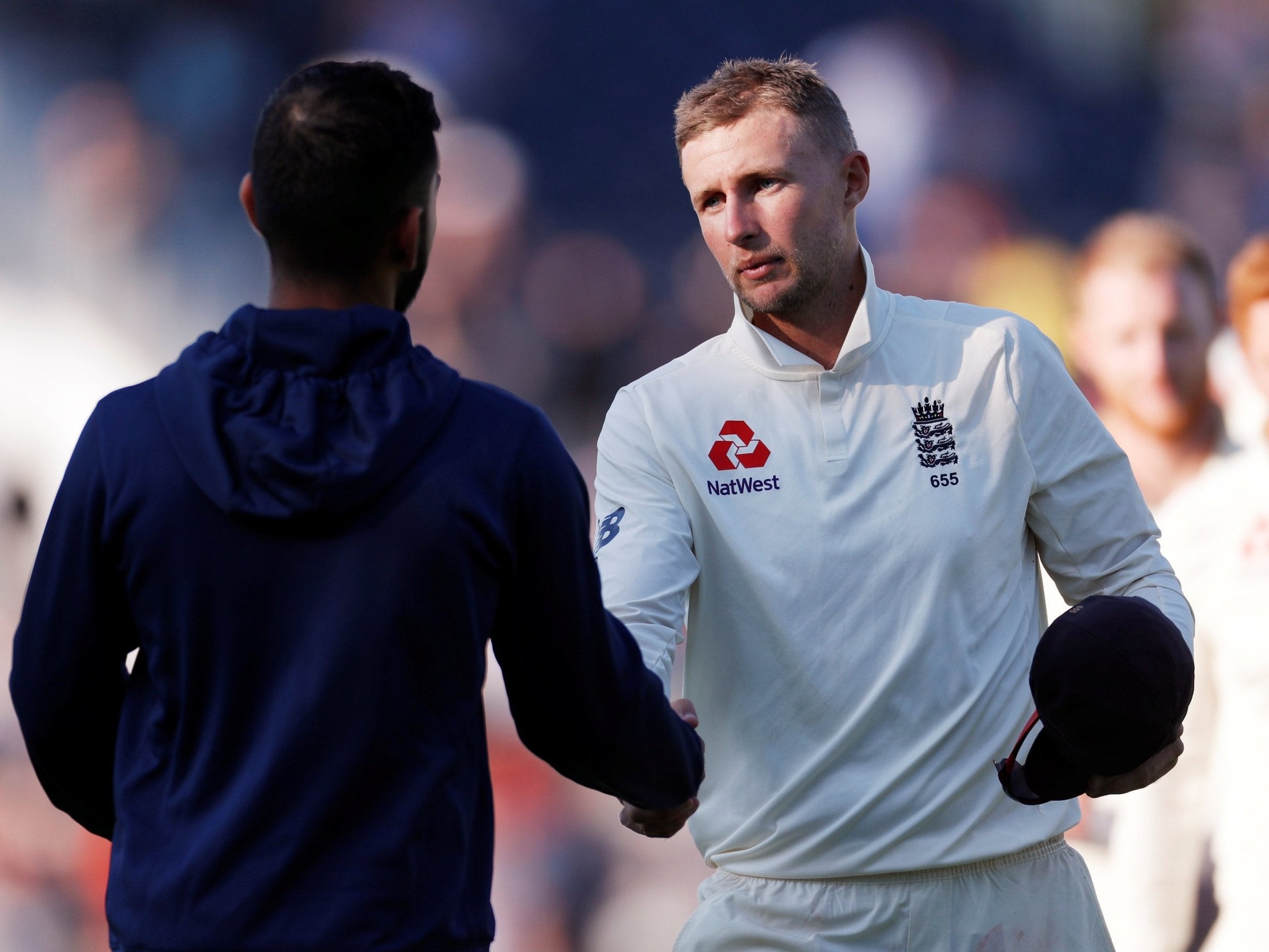 Joe Root is congratulated by opposite captain Virat Kohli