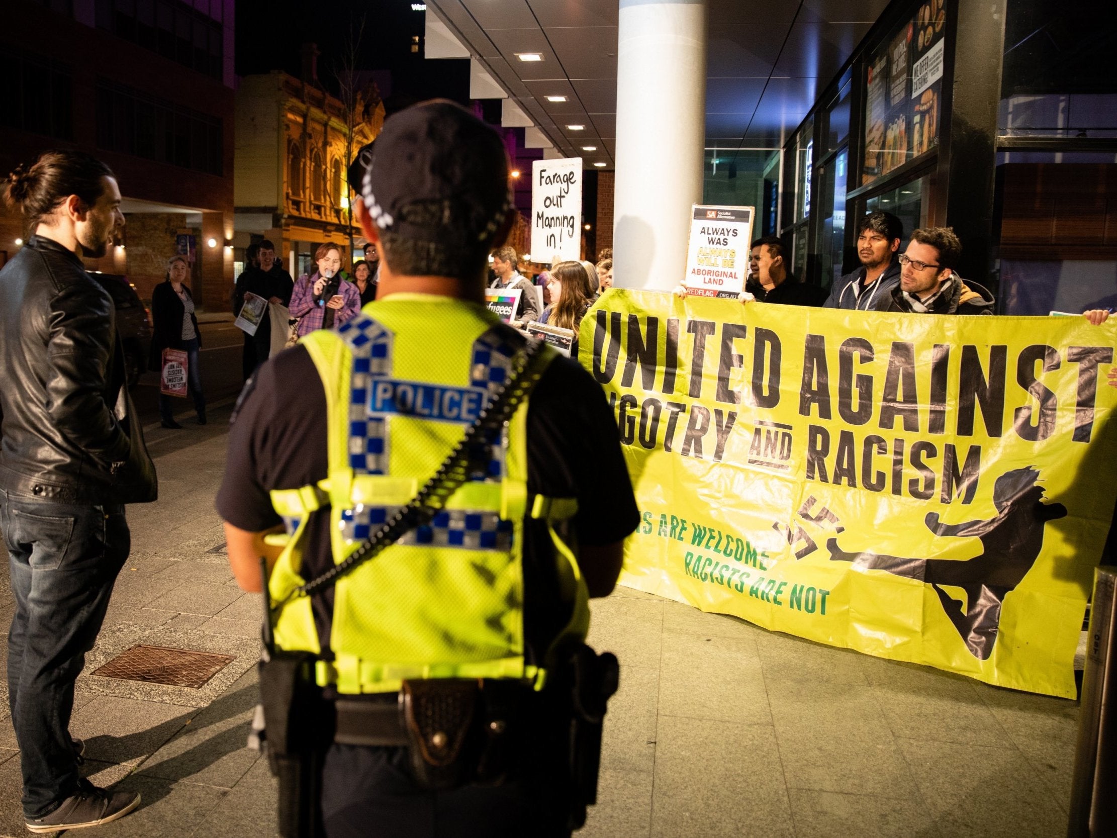 Police watch over protesters outside a venue hosting Nigel Farage in Perth, Australia