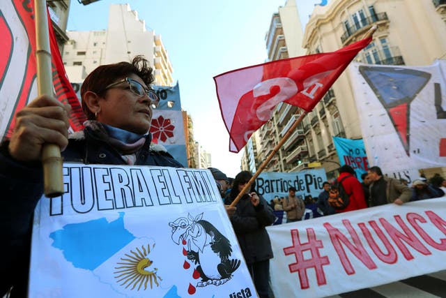 A demonstrator holds a sign that reads "IMF (International Monetary Fund), get out" during a protest against the G20 Meeting of Finance Ministers in Buenos Aires, Argentina, July 21, 2018.