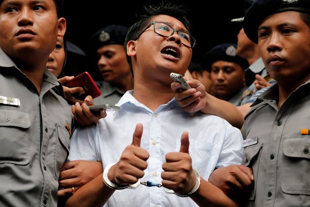 Wa Lone, one of the two arrested journalists, speaks to reporters in handcuffs