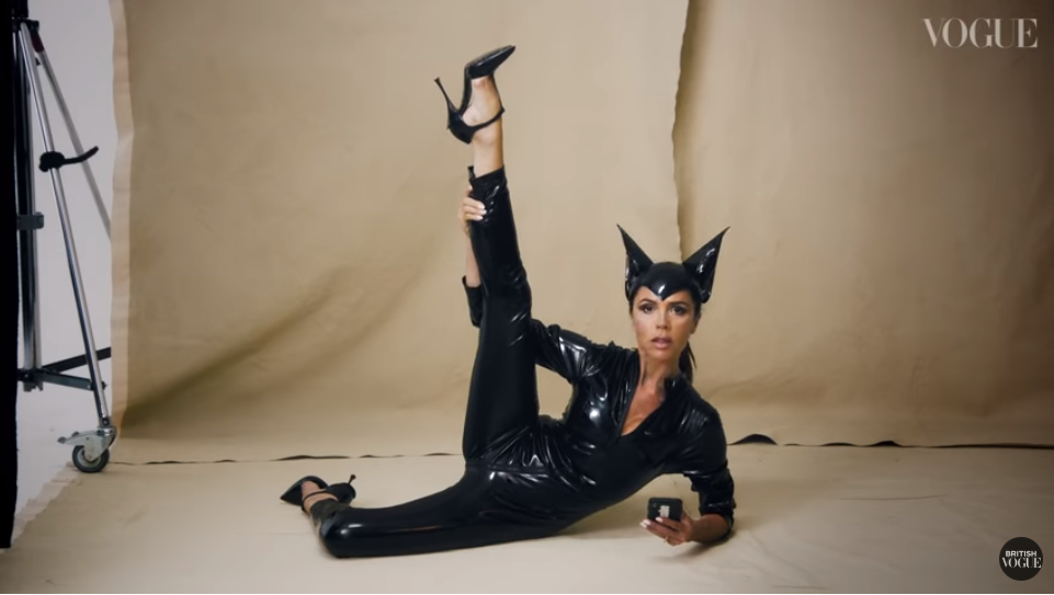 Beckham strikes a pose in her iconic latex cat suit she first wore 22 years ago