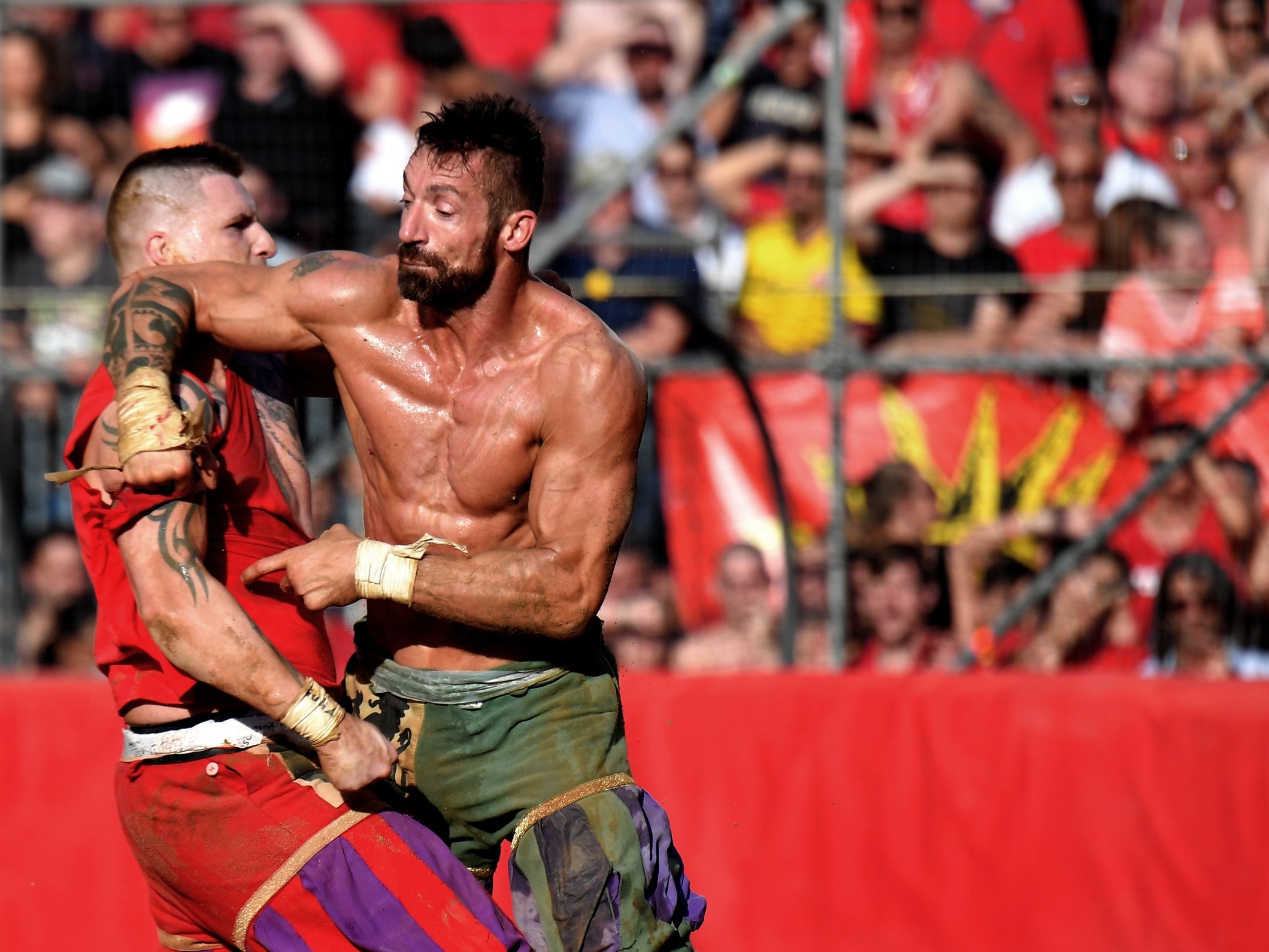 Calcio storico fiorentino players get to grips with each other while competing on the Piazza Santa Croce, Florence