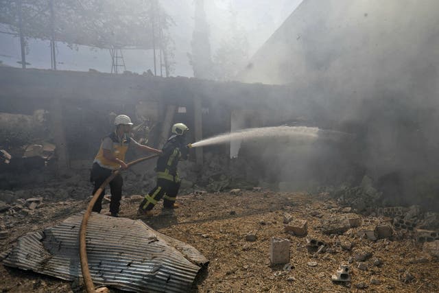 Syrian firefighters try put out a fire in a building that was hit by reported Russian air strikes