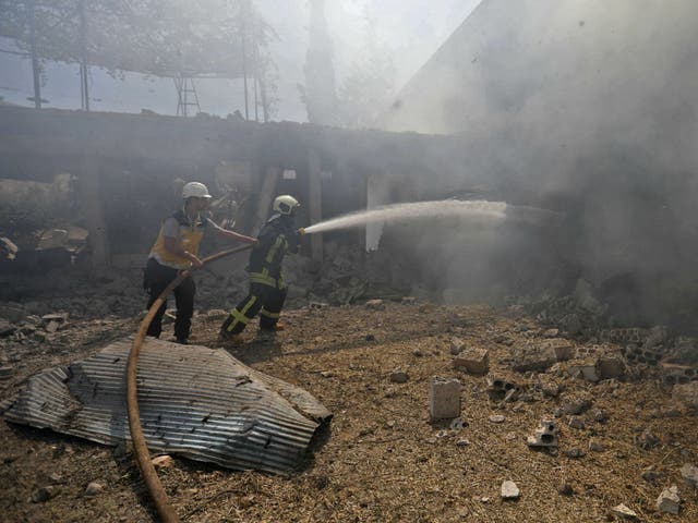 Syrian firefighters try put out a fire in a building that was hit by reported Russian air strikes