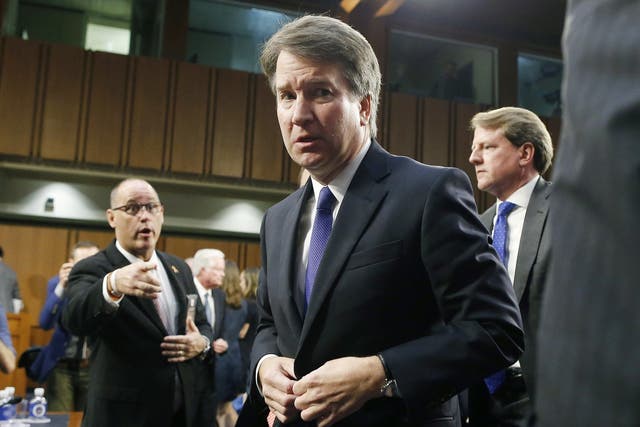 Circuit judge Brett Kavanaugh, centre is approached by Fred Guttenberg, the father of Parkland shooting victim Jaime Guttenberg