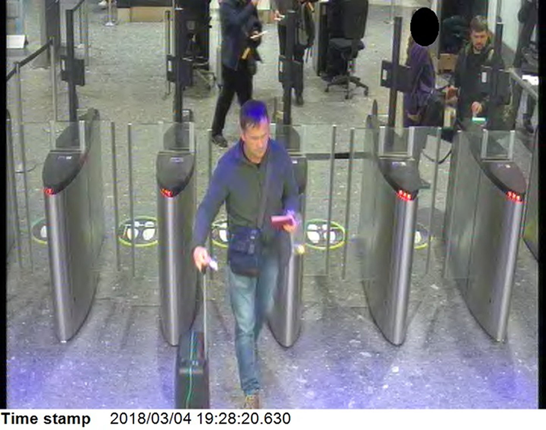 The suspects passing through passport control at London Heathrow at 7.28pm on Sunday evening (4 March)