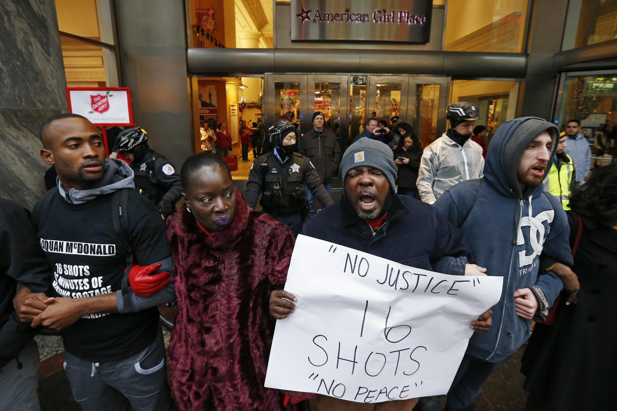 Demonstators link arms in solidarity as they protest the shooting death of black teenager Laquan McDonald by a white policeman and the city’s handling of the case in the downtown shopping district of Chicago, Illinois, 27 November 2015.