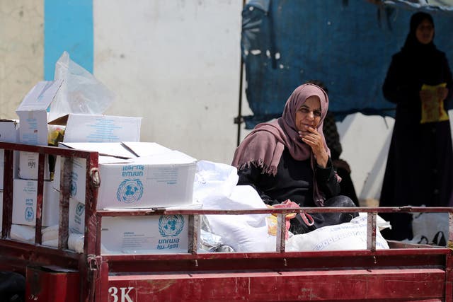 A Palestinian woman sits in a  United Nations vehicle loaded with aid supplies in Gaza Strip