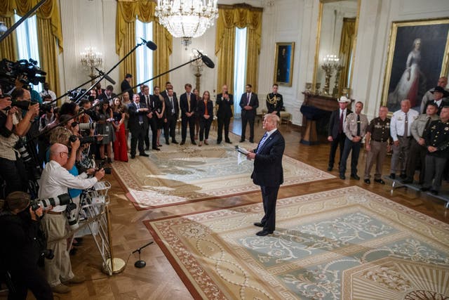 Donald Trump responds to a question from the news media after delivering remarks during a meeting with sheriffs from across the country in the East Room at the White House