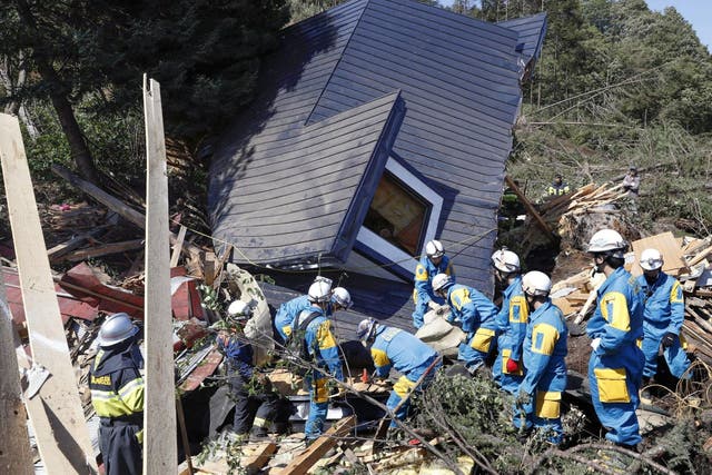 Rescue workers search for survivors from a house damaged by a landslide caused by an earthquake in Hokkaido