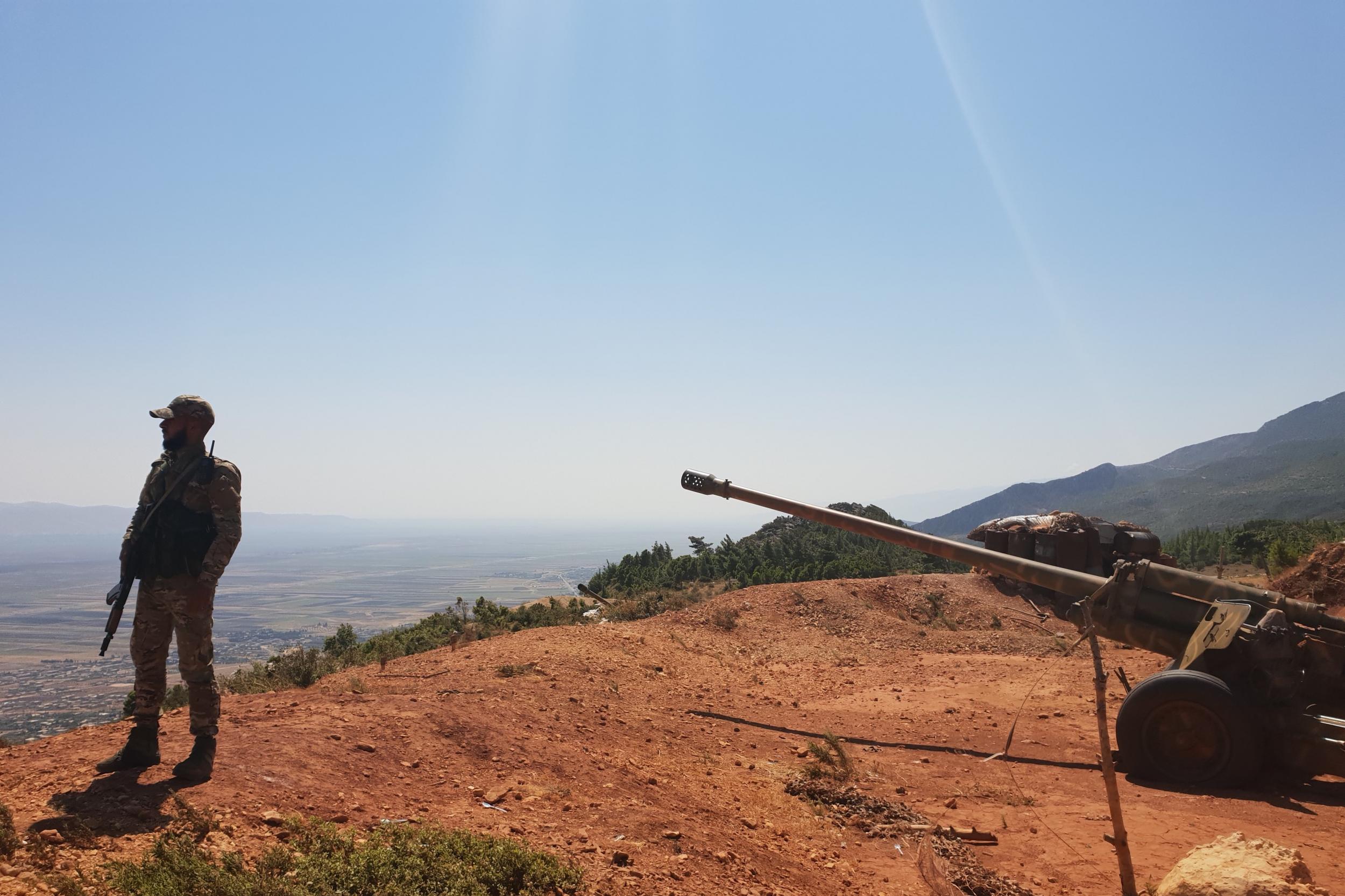 A Syrian soldier stands guard over a Russian-made 130mm gun on the heights of Mount Akrad, northern Syria. Photo: Nelofer Pazira