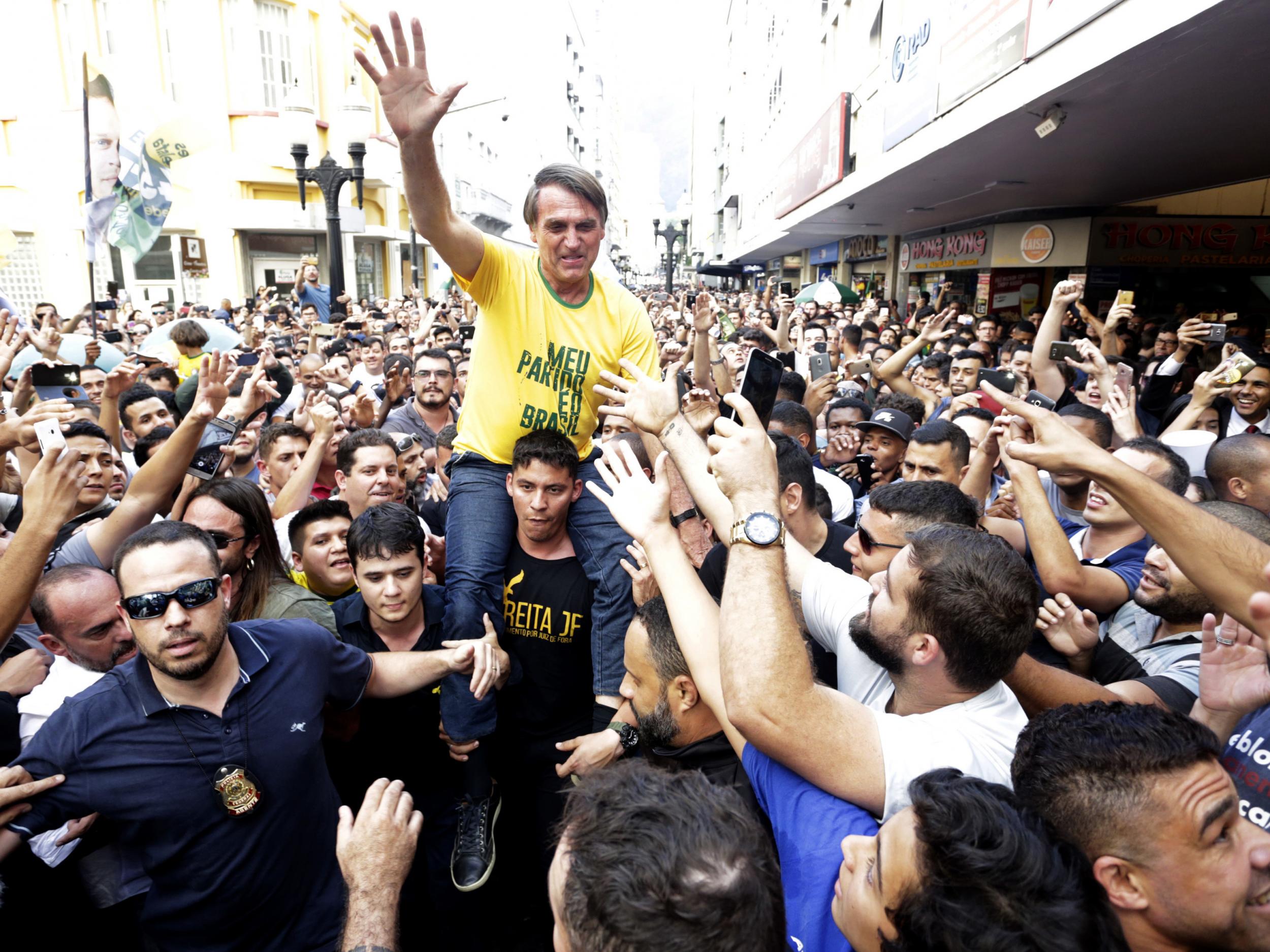 Presidential candidate Jair Bolsonaro is taken on the shoulders of a supporter moments before being stabbed during a campaign rally