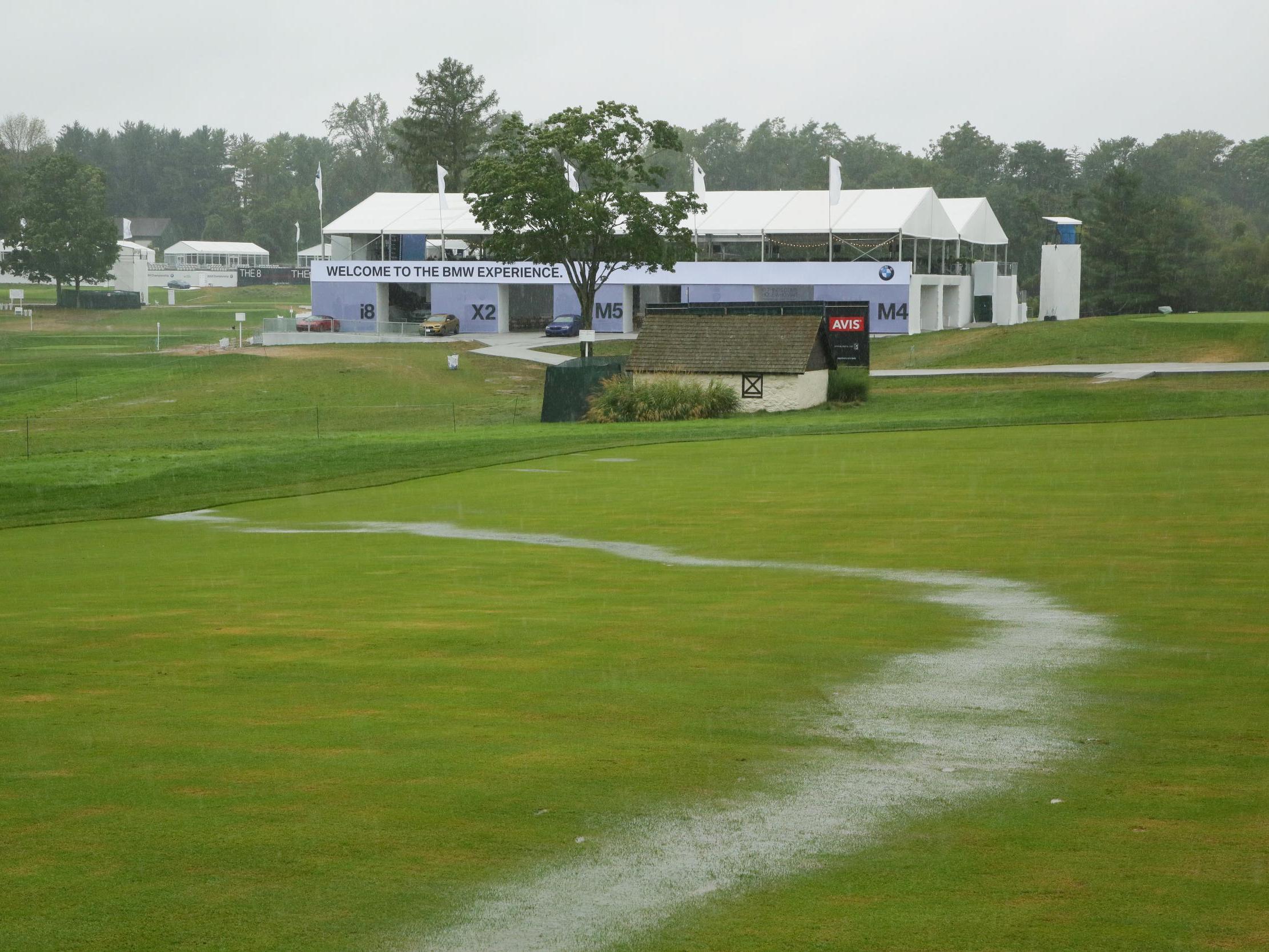 A stream of rain water runs down the 18th fairway