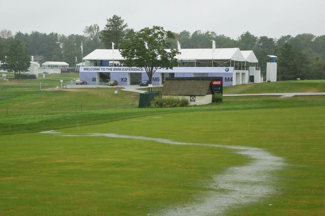 A stream of rain water runs down the 18th fairway