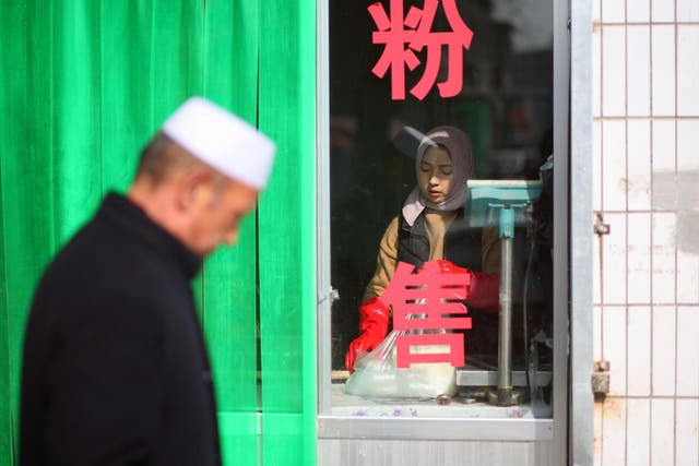 A woman prepares food at a shop in China's Linxia, Gansu province, home to a large population of ethnic minority Hui Muslims
