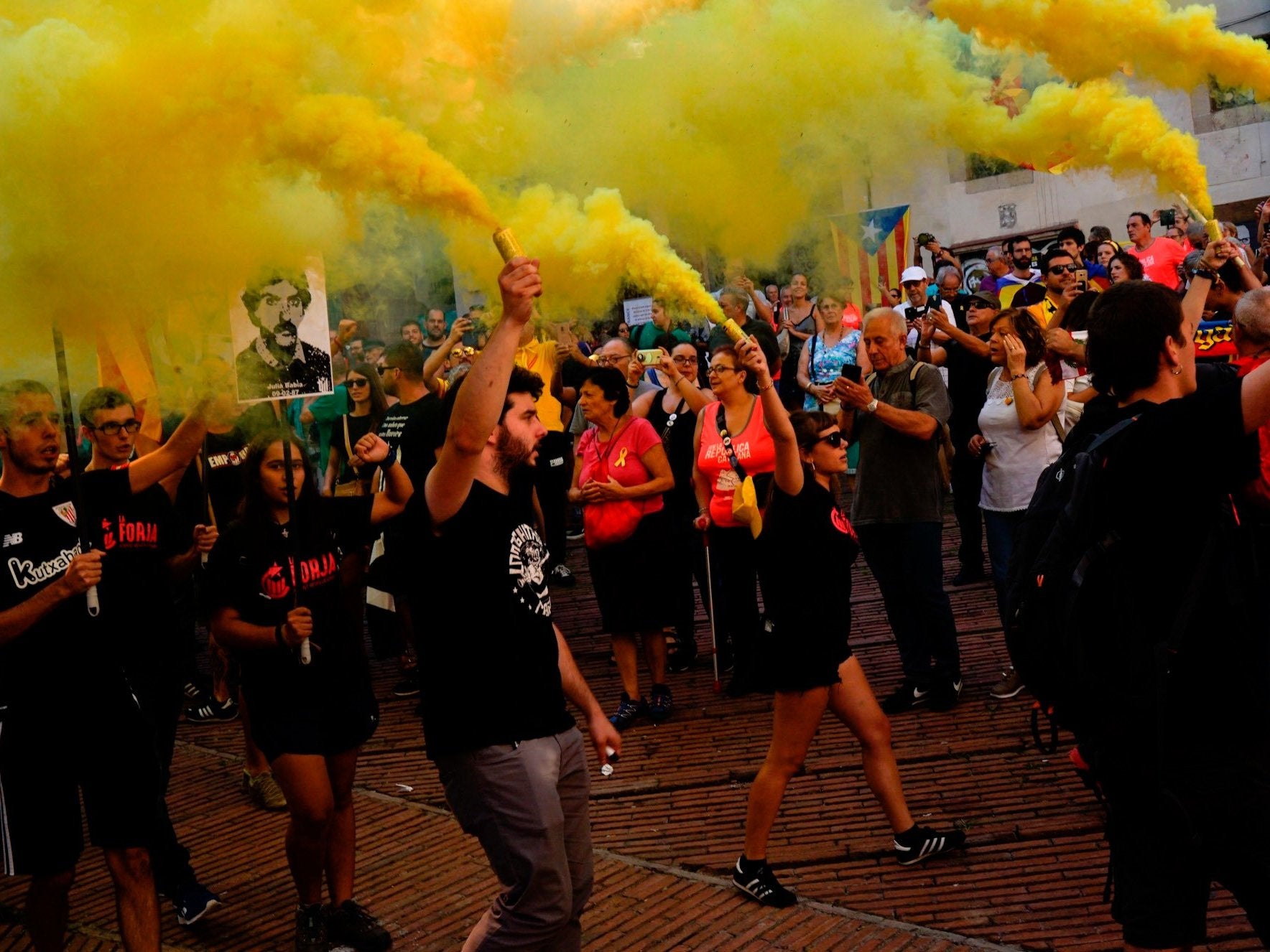 Independence demonstrators, some of them holding flares, march during the Catalan National Day in Barcelona on Tuesday