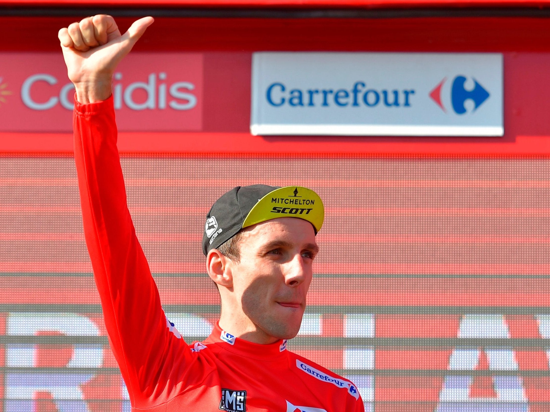 Simon Yates celebrates on the podium after stage 16