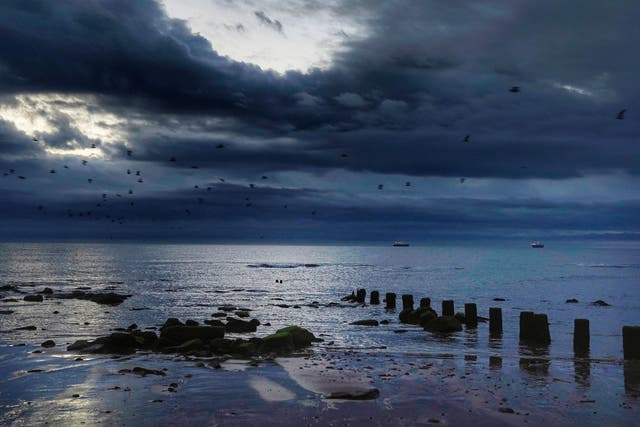 Storm clouds gather over ships on the horizon at Whitley Beach, Tyne and Wear