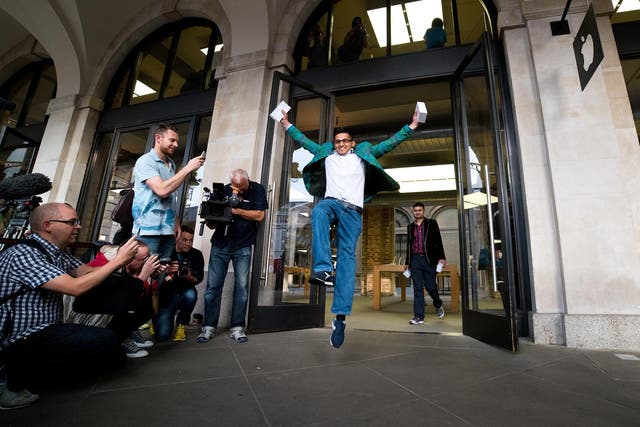 Jamael Ahmed jumps in the air as he leaves the store after being the first to purchase the iPhone 6 at Apple Covent Gardens launch on September 19, 2014 in London, England