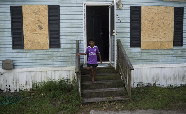 A boy looks on as he exits his mobile home a day before the arrival of Hurricane Florence in Wilmington, North Carolina