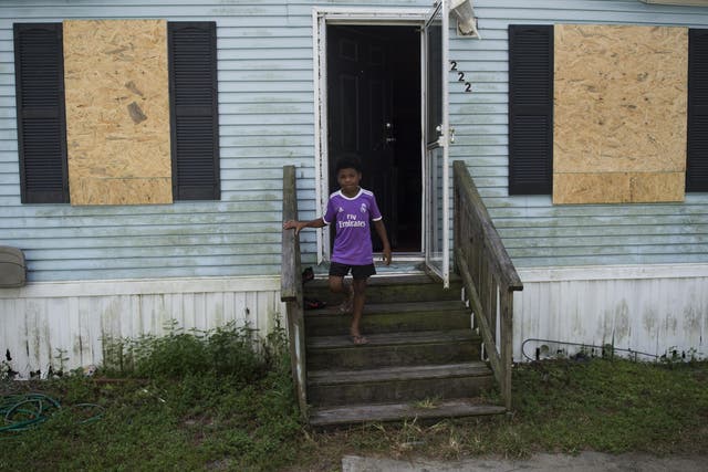 A boy looks on as he exits his mobile home a day before the arrival of Hurricane Florence in Wilmington, North Carolina