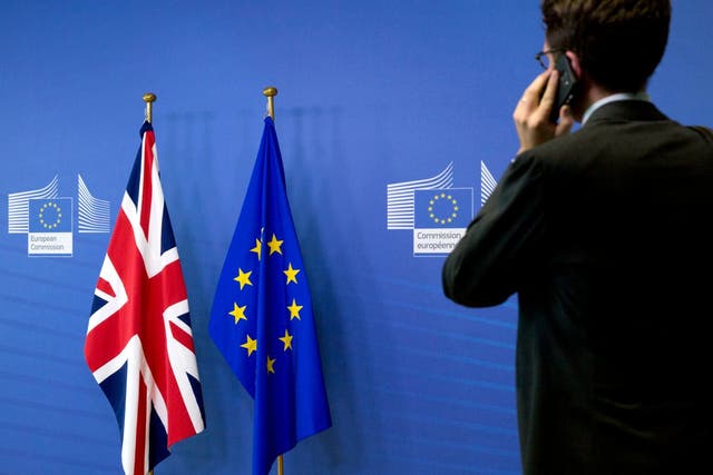 A member of the British delegation speaks on a mobile phone prior to the arrival of Britain's Secretary of State for Exiting the European Union Dominic Raab and EU chief Brexit negotiator Michel Barnier at EU headquarters in Brussels on Friday, Aug. 31, 2018