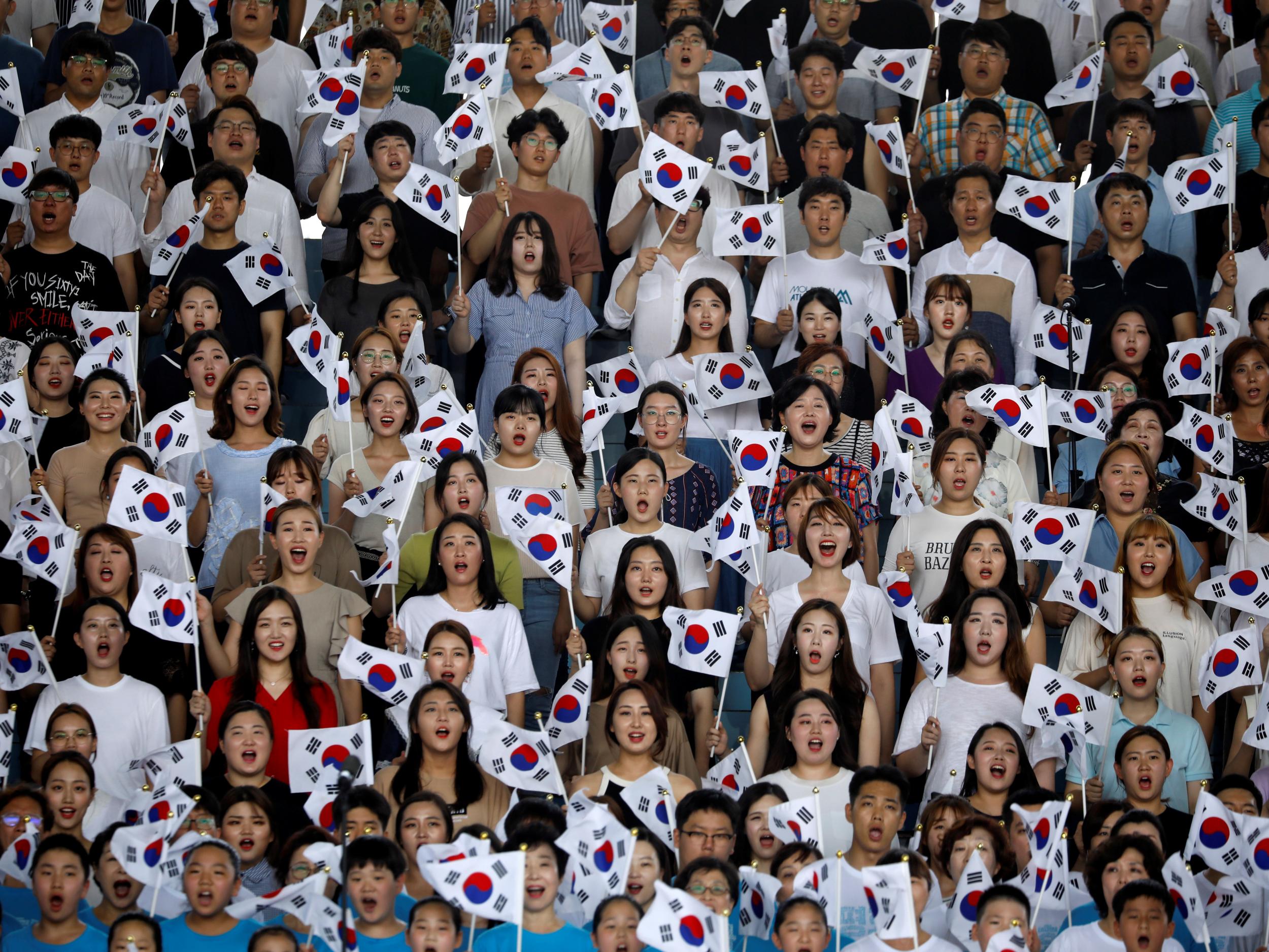 Participants wave South Korean national flags during a ceremony marking the 73rd anniversary of liberation from Japan's 1910-1945 colonial rule following the end of World War Two