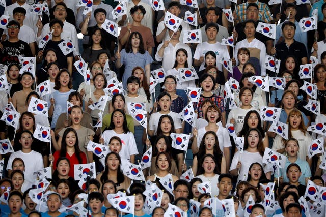 Participants wave South Korean national flags during a ceremony marking the 73rd anniversary of liberation from Japan's 1910-1945 colonial rule following the end of World War Two