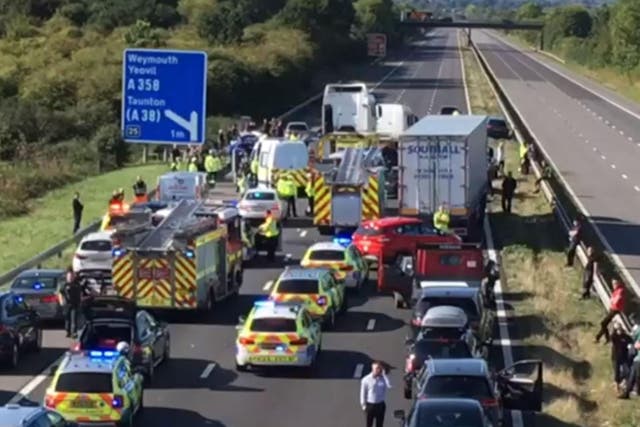 Motorists wait by the roadside after the collision saw the M5 closed