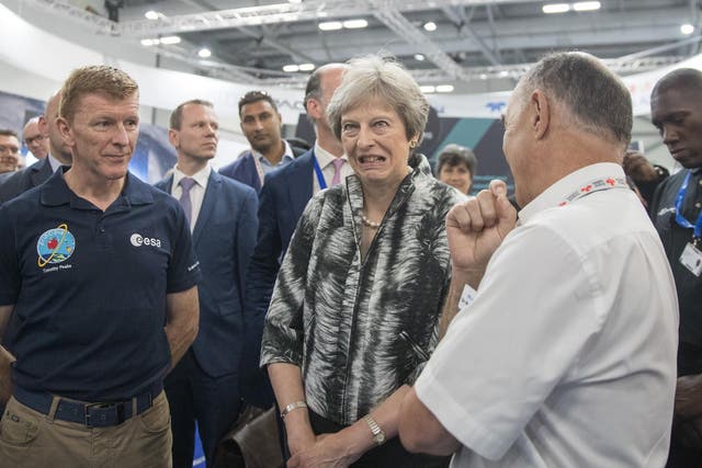 British Prime Minister Theresa May speaks with European Space Agency astronaut Tim Peake (L) as she opens the Farnborough Airshow on July 16, 2018 in Farnborough, England
