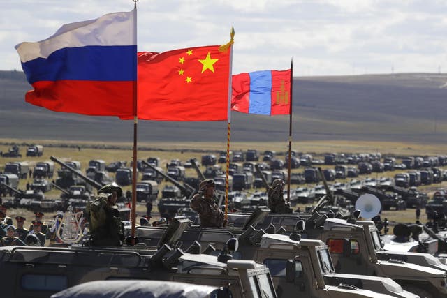 Russian, Chinese and Mongolian national flags set on armored vehicles develop in the wind during a military exercises on training ground "Tsugol"