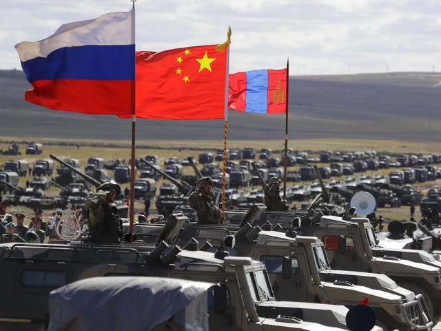 Russian, Chinese and Mongolian national flags set on armored vehicles develop in the wind during a military exercises on training ground "Tsugol"