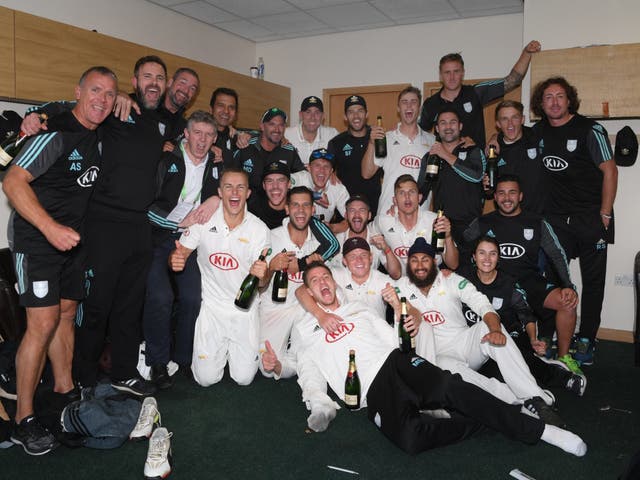 Surrey players and staff celebrate in the dressing room