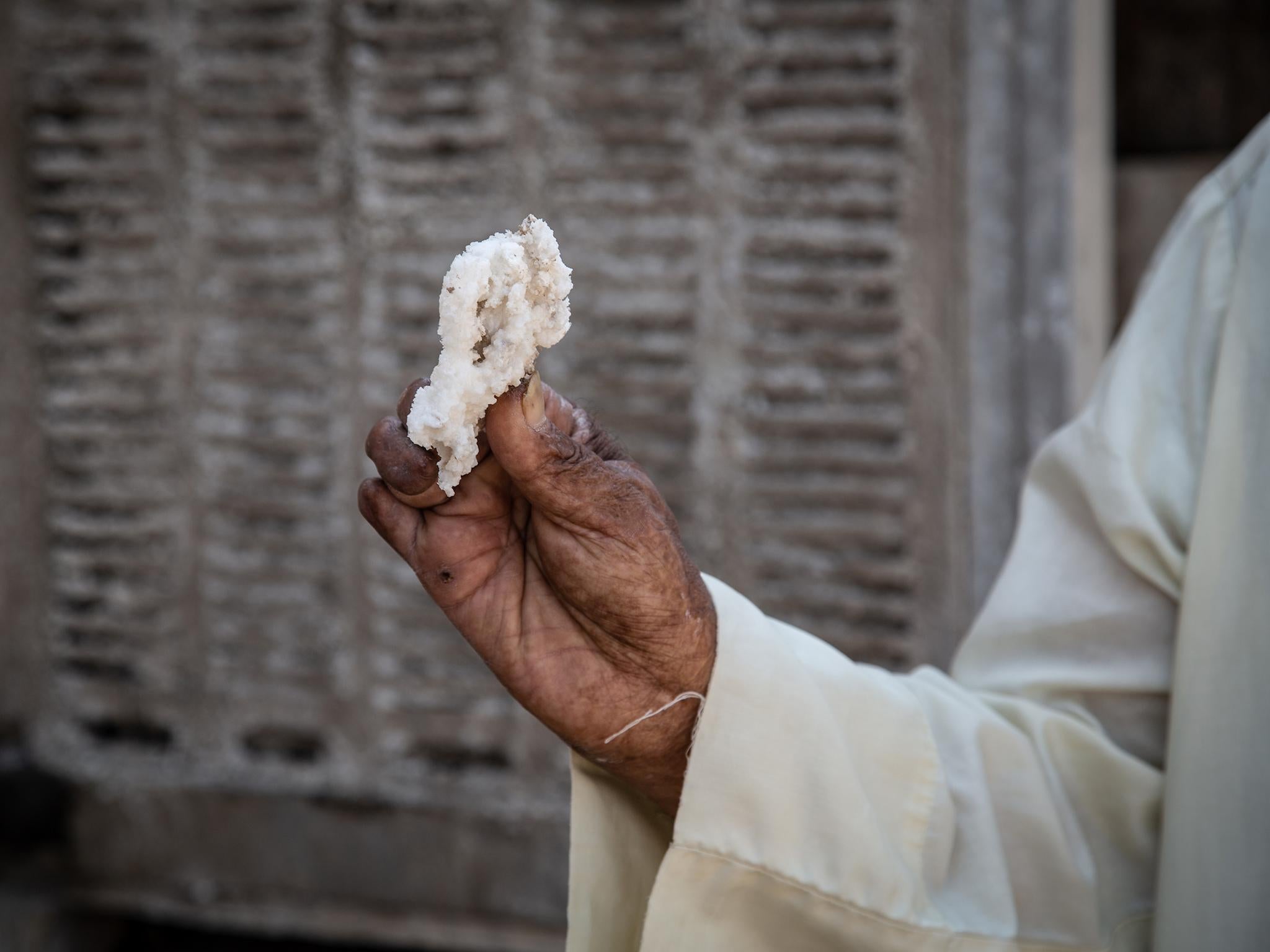 Chunks of salt crystallise onto the pipes of Hamid Abdul-Wahib's home in the blazing heat of the summer