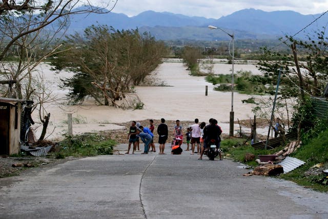 Residents stand by a flooded road in Cagayan province following the onslaught of Typhoon Mangkhut