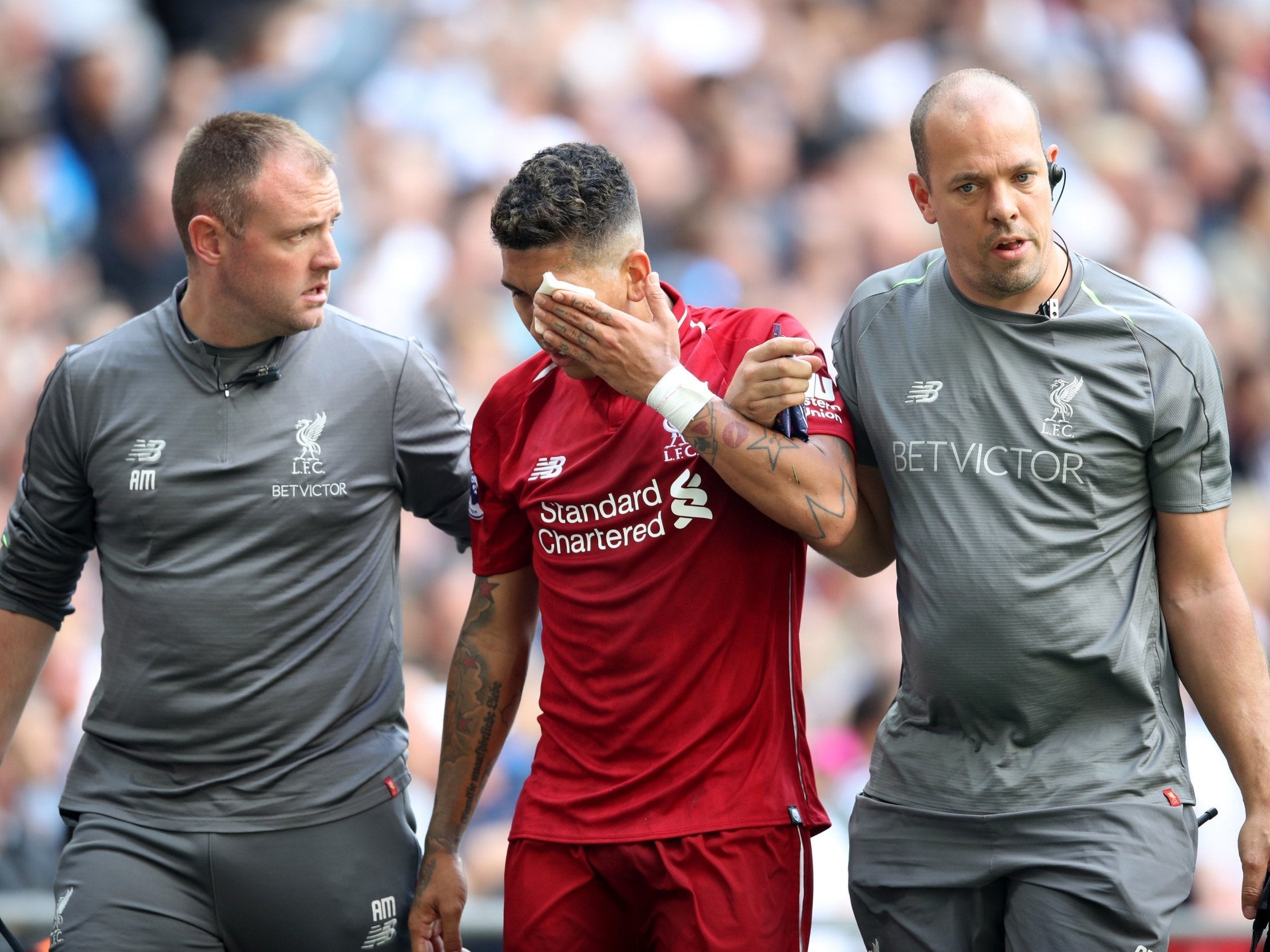 Roberto Firmino leaves the field after suffering an eye injury