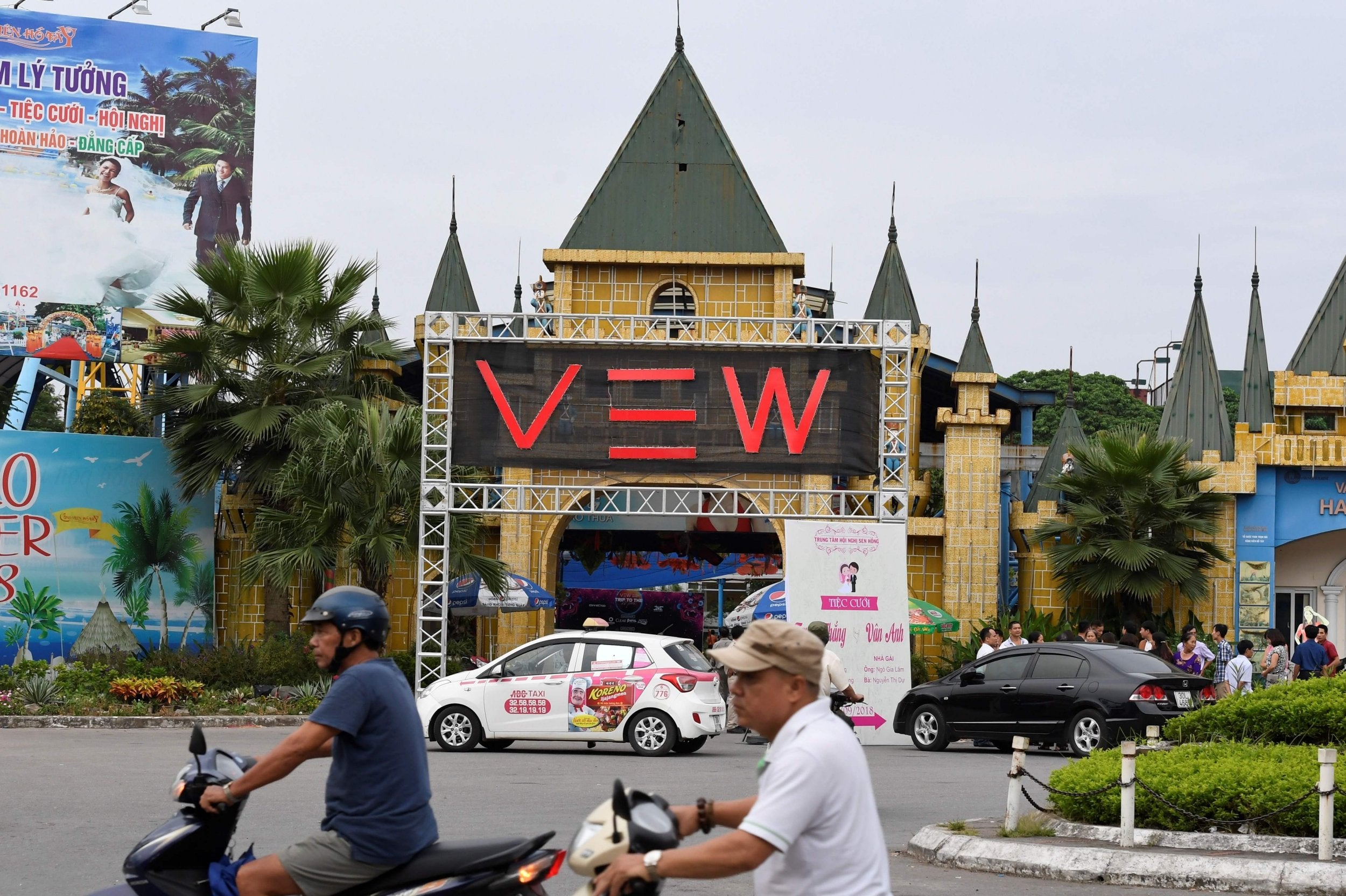 Commuters pass the entrance to the West Lake Water Park in Hanoi where partygoers died from drug use during electronic dance music festival 'Trip to the moon' inside the park