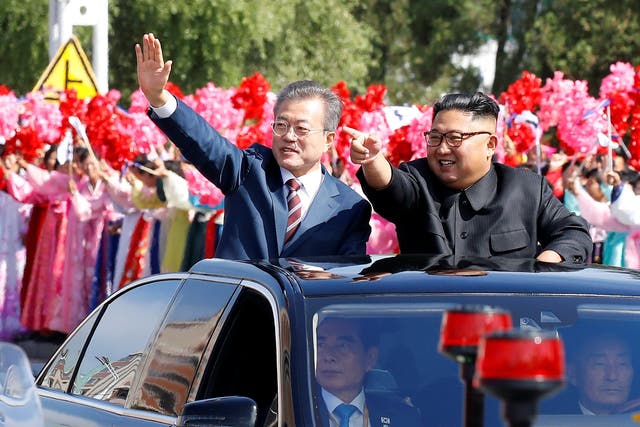 South Korean President Moon Jae-in and North Korean leader Kim Jong-un wave during a car parade in Pyongyang