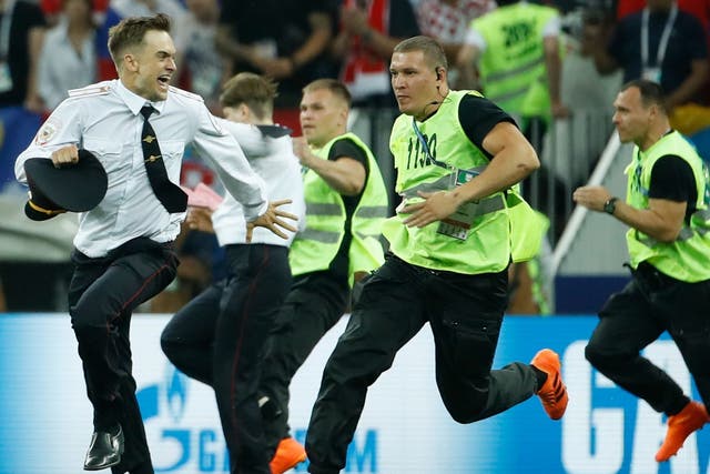 Stewards chase Pussy Riot member Pyotr Verzilov during a pitch invasion protest at the 2018 World Cup Final in Moscow