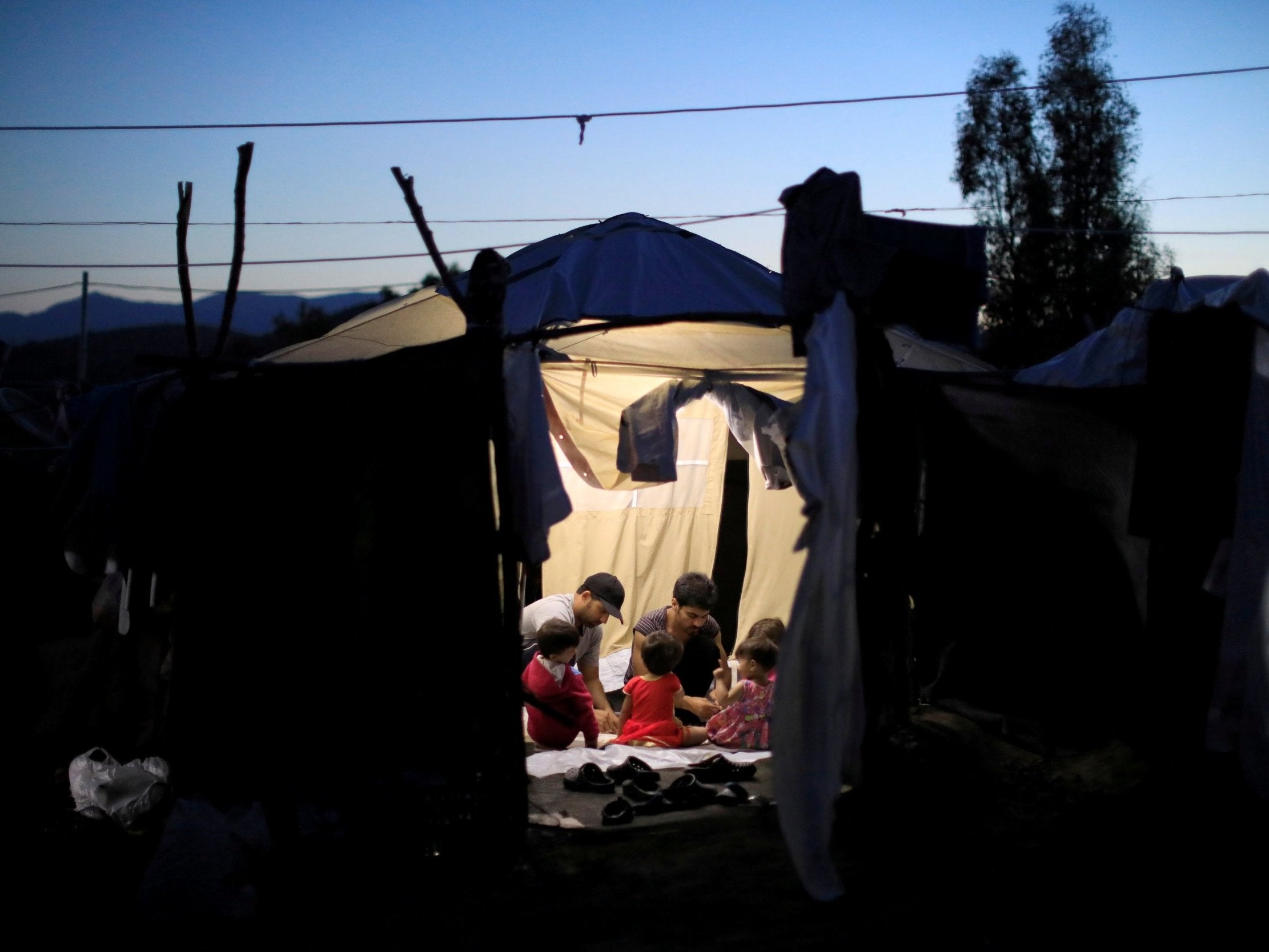 Migrants are pictured in a tent in Greece