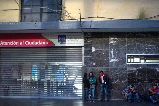 People wait in line outside Saime offices in Caracas  