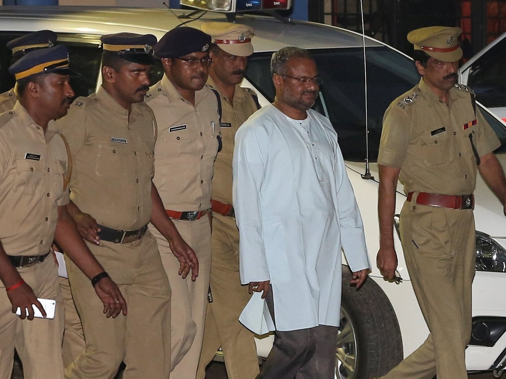 Bishop Franco Mulakkal, dressed in white, is escorted by police in Kochi, India