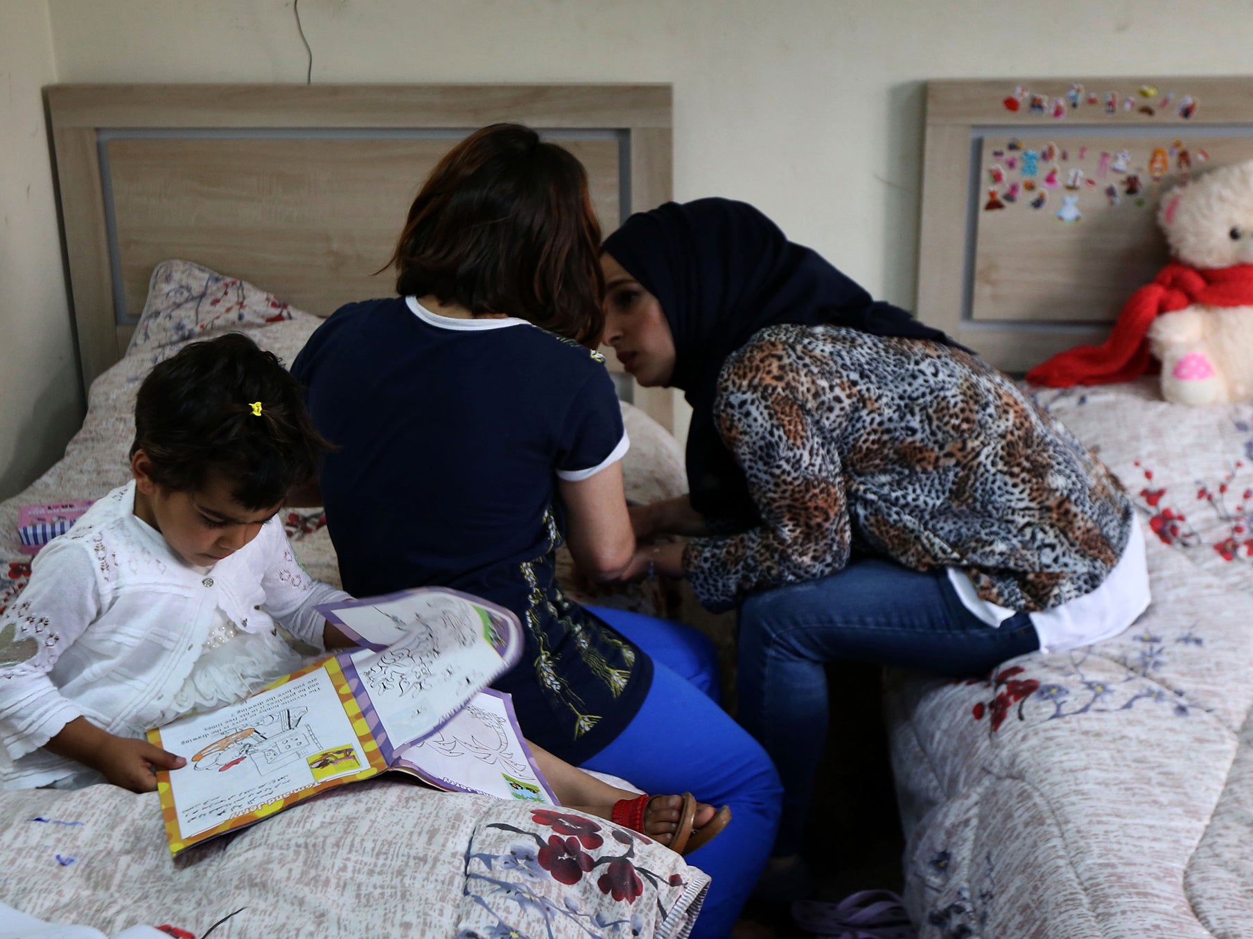 Two displaced Iraqi sisters from Mosul with an employee of their orphanage in Irbil in 2017