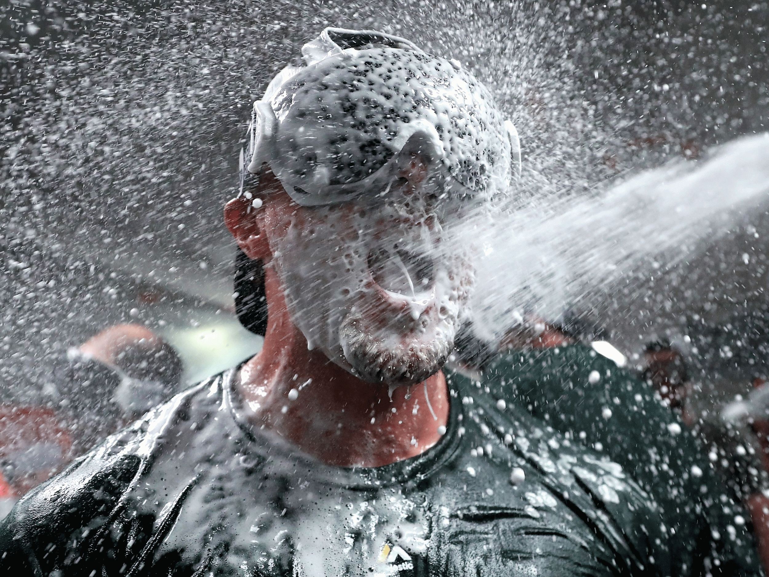 Jed Lowrie is covered in beer and champagne as Oakland reach the playoffs
