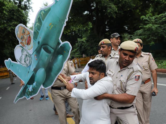 Indian security personnel detain an opposition activist during a protest against the BJP over the Rafale deal in Delhi on Saturday