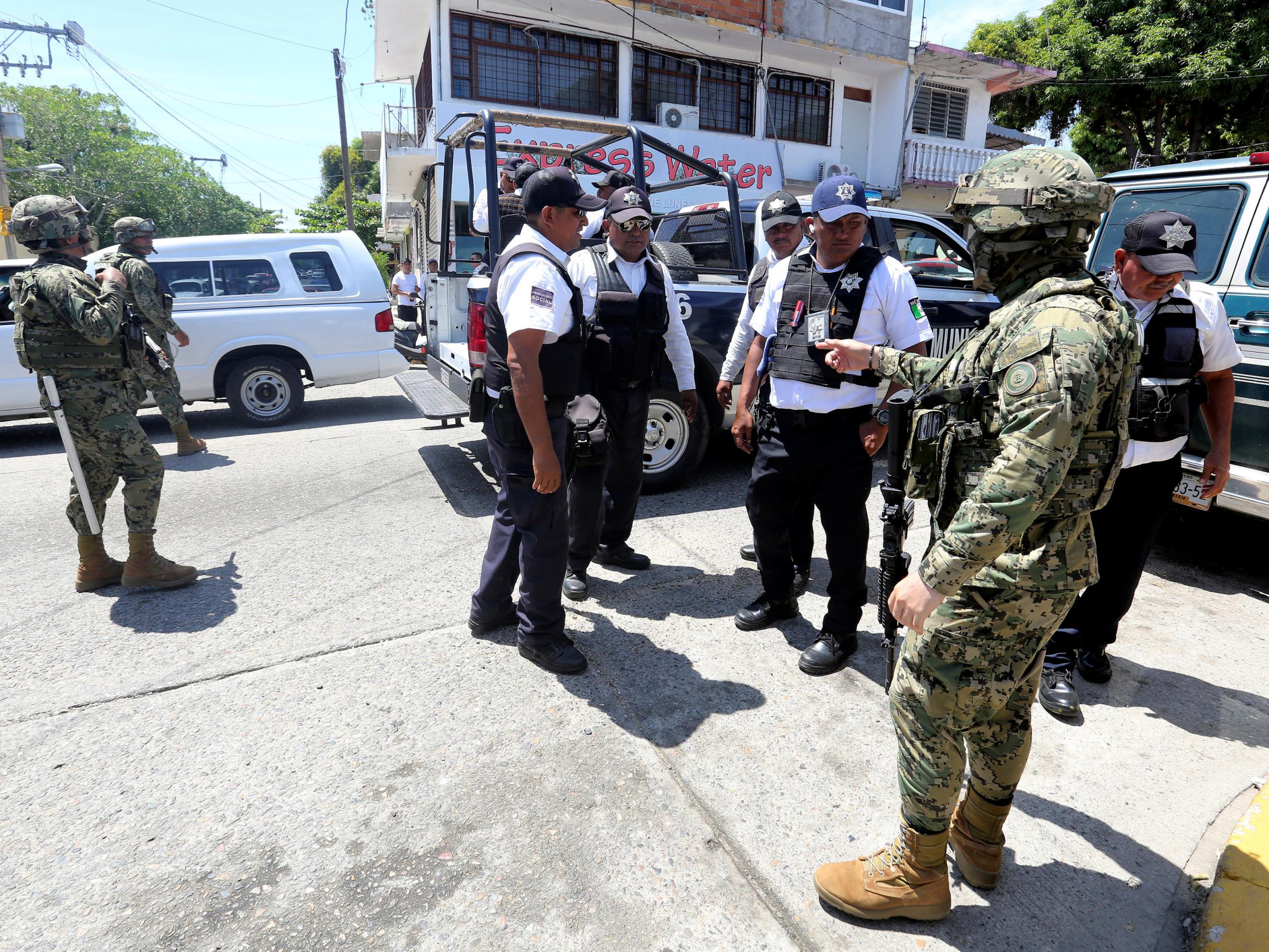 Mexican marines escort municipal police officers disarmed and detained during an operation to check if they colluded with organised crime, in Acapulco, Mexico September 25, 2018